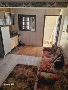 a living room with a couch and a kitchen at Duplex 2 quartos pertinho da Praia in Tramandaí +3 photos