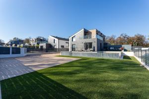 a house with a green lawn in front of it at Villa Porta Verde IV - Infinity pool BBQ Luxury in Balatonalmádi