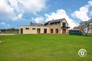 a large house with a large green field in front of it at La casa de silz in Arzal
