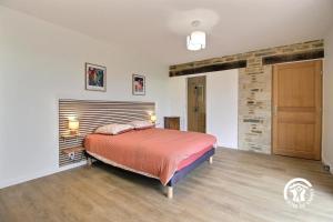 a bedroom with a bed and a brick wall at La casa de silz in Arzal