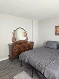 a bedroom with a bed and a dresser with a mirror at Convenient Downtown Apartment in Saint Louis