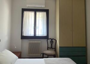 a bedroom with a bed and a window and a chair at Sarnico Terrazza sul lago di Iseo in Sarnico