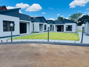 a large house with a yard in front of it at Xitshavani Lodge in Phalaborwa