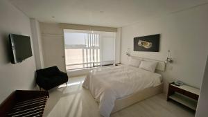 a bedroom with a bed and a large window at Le Grand Hotel Ilo in Ilo