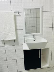 a white bathroom with a sink and a mirror at Xitshavani Lodge in Phalaborwa +18 photos