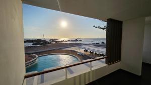 a room with a view of the ocean from a balcony at Le Grand Hotel Ilo in Ilo