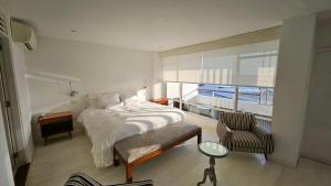 a bedroom with a bed and a chair and a window at Le Grand Hotel Ilo in Ilo +54 photos