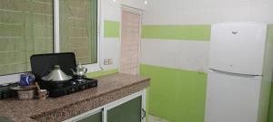 a kitchen with green and white walls and a refrigerator at Zerarda in Saïss +8 photos