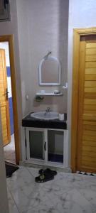 a bathroom with a sink and a mirror at Zerarda in Saïss