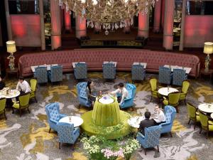 a group of people sitting at tables in a restaurant at Grand Mercure Imperial Palace Seoul Gangnam in Seoul