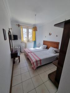 a bedroom with a bed and a television in it at Maria Guest house in Albufeira