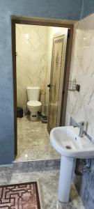 a bathroom with a white sink and a toilet at Tata hôte in Tatta