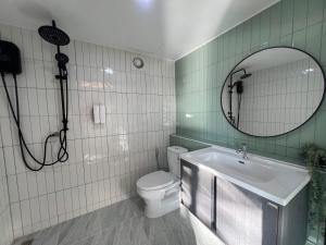 a bathroom with a toilet and a sink and a mirror at SafeHouse resort เซฟเฮ้าท์รีสอร์ท in Ban Laem Phai