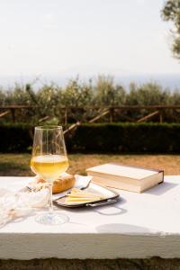 a glass of wine sitting on a table with a book at Amira Capri in Anacapri