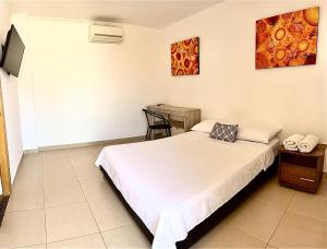 a bedroom with a bed and a desk in it at Hotel Ocean Taganga Internacional in Taganga