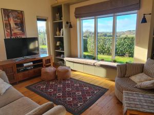 a living room with two couches and a large window at Three Hares Farmhouse, Galway in Craughwell