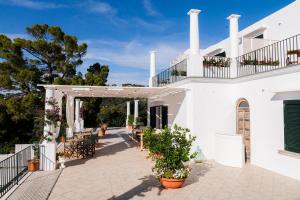 a white building with a patio with plants at Amira Capri in Anacapri +21 photos