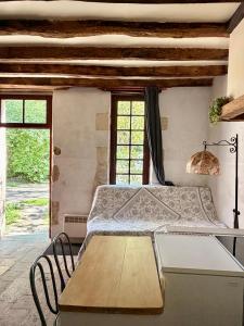 a bedroom with a bed and a table and windows at Aux Ecuries du Signe in Amboise