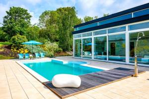 a house with a swimming pool in front of it at Villa Bianca in Dalhem