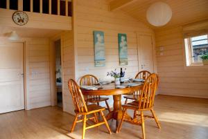 a dining room with a wooden table and chairs at Lapwing Lodge in Dumfries +17 photos