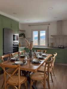 a kitchen with a wooden table with chairs around it at Villa Rosa in Melgaço