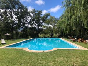 a swimming pool in the yard of a house at Hermosa Cabaña El Nogalito Mina Clavero in Mina Clavero