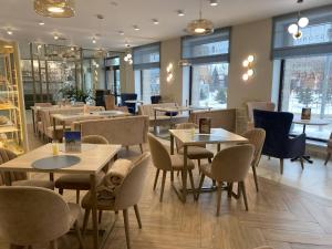 a restaurant with tables and chairs and windows at River Stone in Pavlodar