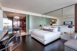 a bedroom with a large white bed and a kitchen at Palms Place No Resort fees with Balcony in Las Vegas +55 photos