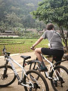 a man riding a bike down a road at Nùng An homestay-Nùng ethnic group in Bà Dương