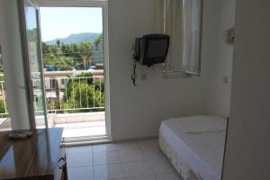 ein Zimmer mit Toilette und Fenster mit Fernseher in der Unterkunft Ünal Boutique Hotel in Kemer