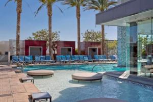 a swimming pool with lounge chairs and palm trees at Palms Place No Resort fees with Balcony in Las Vegas