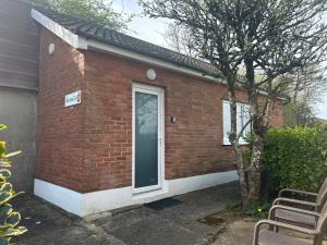 a red brick house with a door and a tree at Appletree Cottage in Waterford