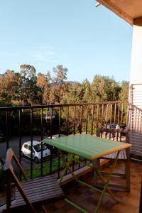 a green table on a balcony with a car at Charming apartment in Porto-Vecchio in Porto-Vecchio