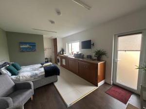 a bedroom with a bed and a couch and a window at Appletree Cottage in Waterford