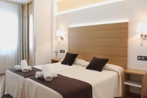 two beds in a hotel room with white towels at Hotel La Noyesa *** Superior in O Grove +29 photos