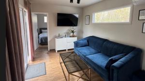 a living room with a blue couch and a television at Domki La Bella 1 in Aleksandria