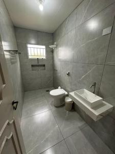 a bathroom with a toilet and a sink at Johnnys motel hotel in Jacarèzinho
