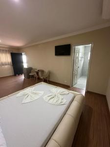 a large white bed in a room with a table at Johnnys motel hotel in Jacarèzinho +4 photos