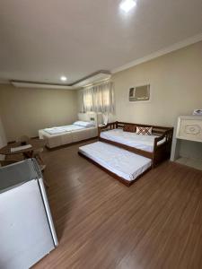 a large room with two beds and a desk at Johnnys motel hotel in Jacarèzinho