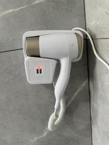 a white hairdryer hanging on a wall at Johnnys motel hotel in Jacarèzinho