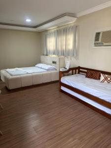 a room with two beds and a laptop in it at Johnnys motel hotel in Jacarèzinho