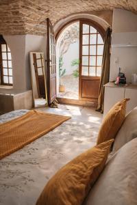 a bedroom with an open door and a bed in a room at La Cachette in Aigues-Vives