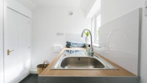 a kitchen with a stainless steel sink and a window at Borth Mawr in Rhosneigr +72 photos