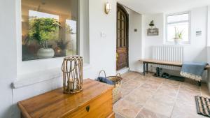 a living room with a wooden table and a bench at Borth Mawr in Rhosneigr