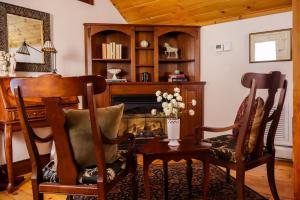 a living room with two chairs and a fireplace at Stonecroft Inn in Ledyard Center