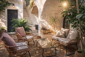 a patio with wicker chairs and a couch at La Cachette in Aigues-Vives