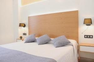 a bedroom with a white bed with two pillows at Hotel La Noyesa *** Superior in O Grove