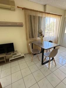 a dining room with a table and chairs and a television at Luxury Beach House 2 in Xiropigado