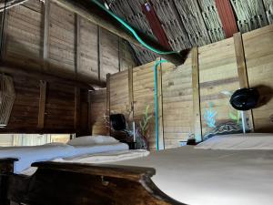 a bedroom with two beds in a room with wooden walls at Casa en el agua in Tintipan Island