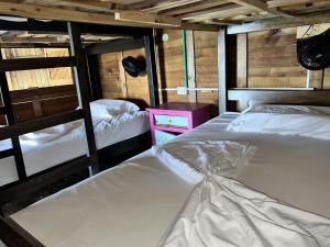 a bedroom with two beds and a pink night stand at Casa en el agua in Tintipan Island +57 photos